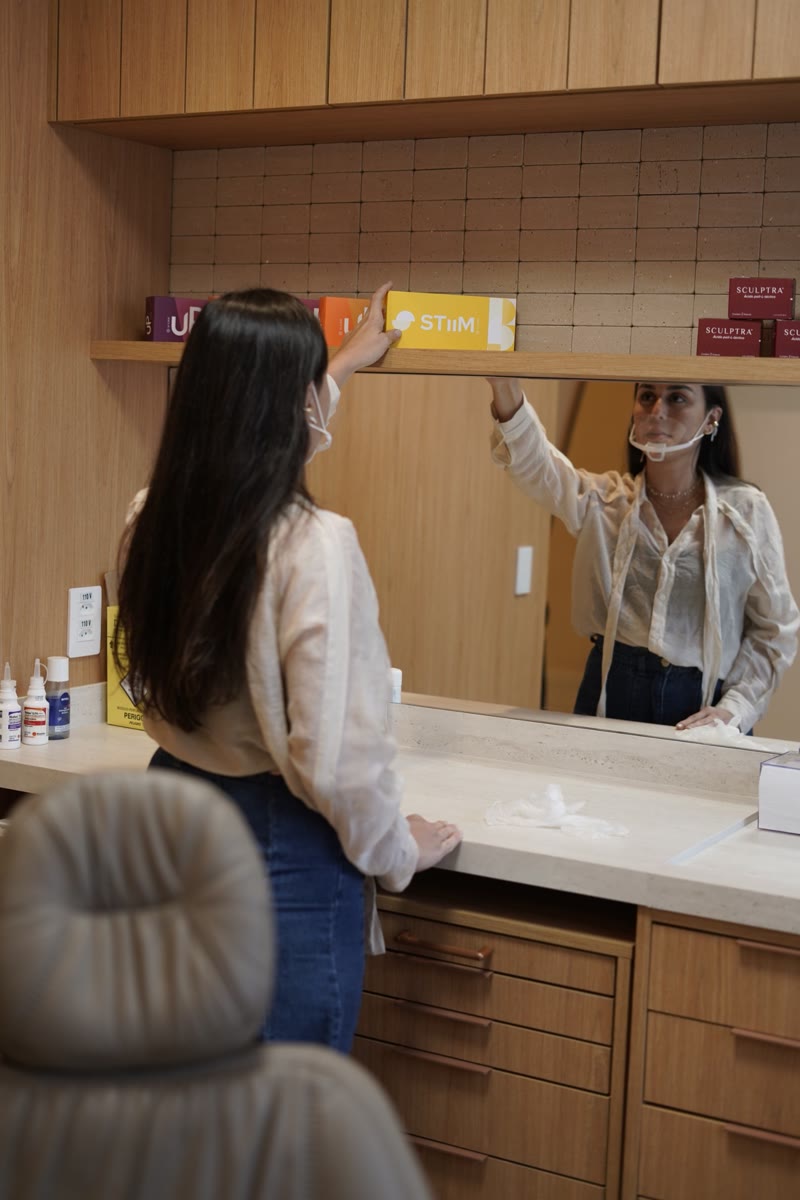 Dra. Joana Helena organizando os produtos na bancada do consultório